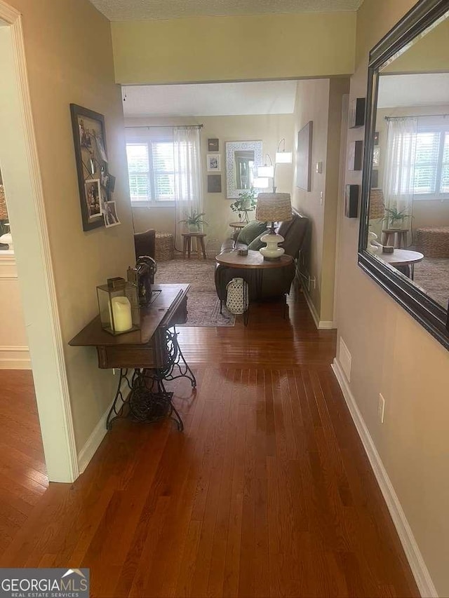 corridor with dark wood-type flooring and plenty of natural light