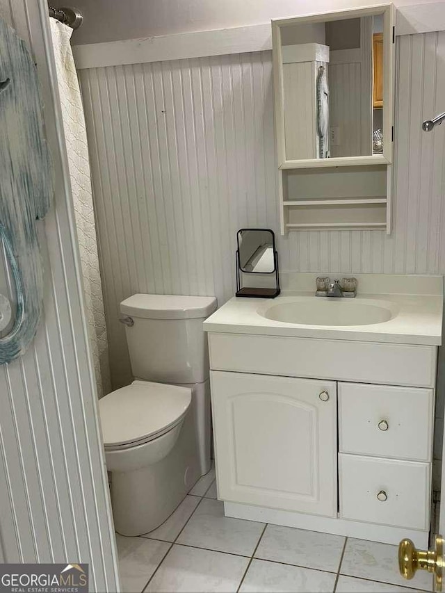 bathroom featuring vanity, tile patterned floors, and toilet