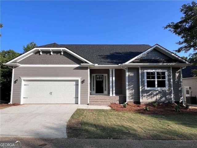 view of front of property featuring central AC, a garage, and a front lawn