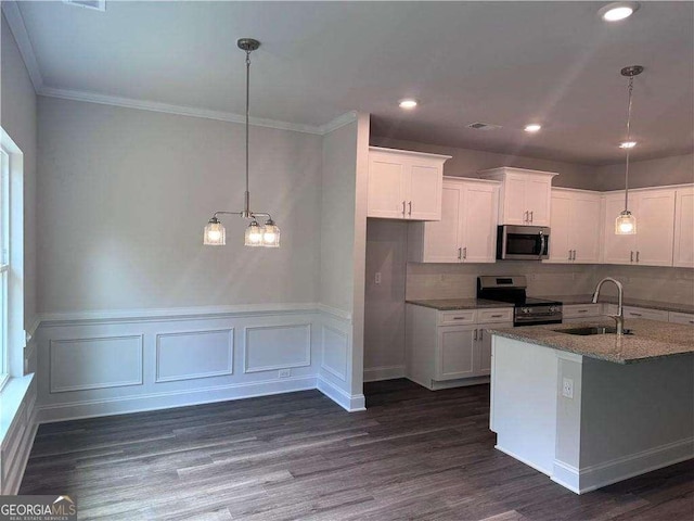 kitchen with pendant lighting, sink, white cabinets, stainless steel appliances, and light stone countertops