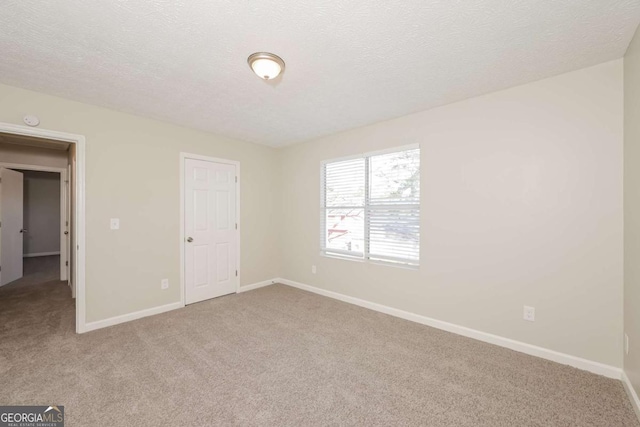 unfurnished bedroom featuring light carpet and a textured ceiling