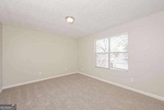 carpeted empty room with a textured ceiling