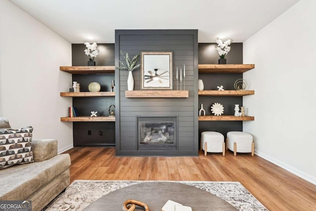 living room with a large fireplace and light wood-type flooring