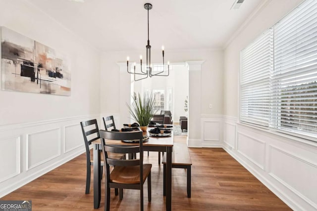 dining area featuring an inviting chandelier, crown molding, and dark hardwood / wood-style floors