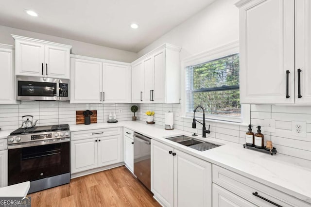 kitchen featuring white cabinetry, sink, and appliances with stainless steel finishes