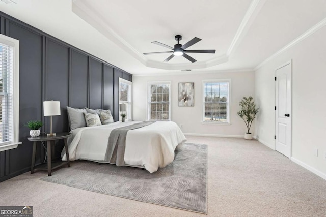 carpeted bedroom with crown molding, a raised ceiling, and ceiling fan