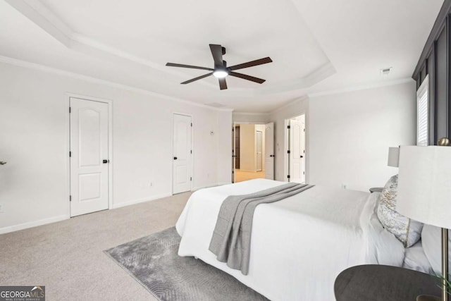 carpeted bedroom featuring a raised ceiling, crown molding, and ceiling fan