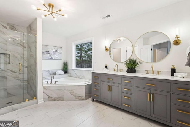 bathroom with a chandelier, vanity, and separate shower and tub