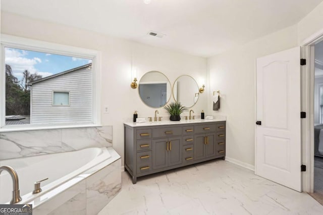 bathroom with vanity and tiled bath