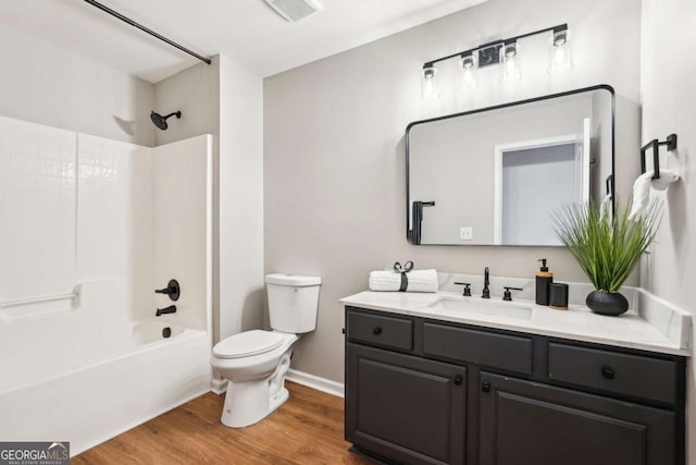 full bathroom with shower / bathing tub combination, vanity, wood-type flooring, and toilet