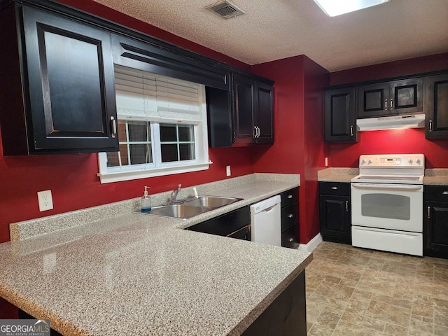 kitchen with white appliances, sink, and a textured ceiling