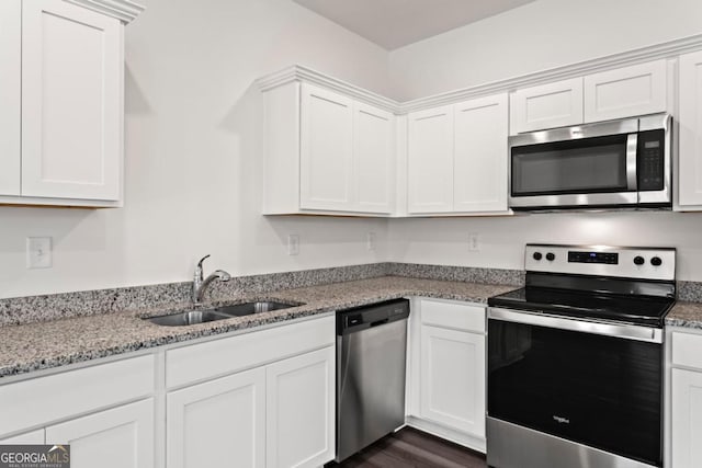 kitchen featuring white cabinetry, sink, light stone counters, and appliances with stainless steel finishes