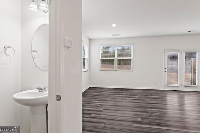 bathroom with hardwood / wood-style flooring and a notable chandelier