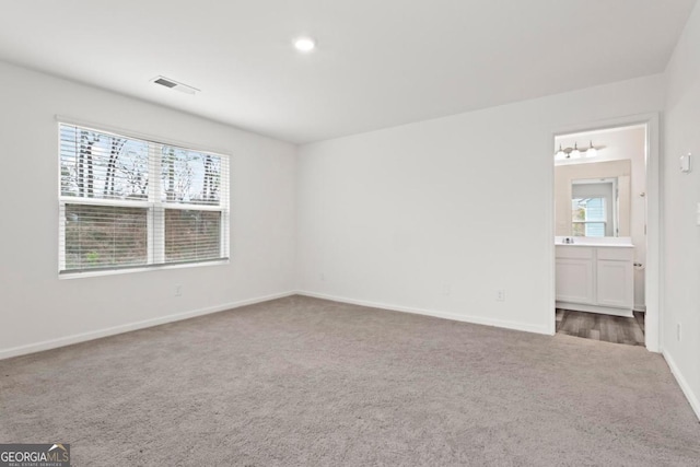 empty room with a healthy amount of sunlight and carpet floors