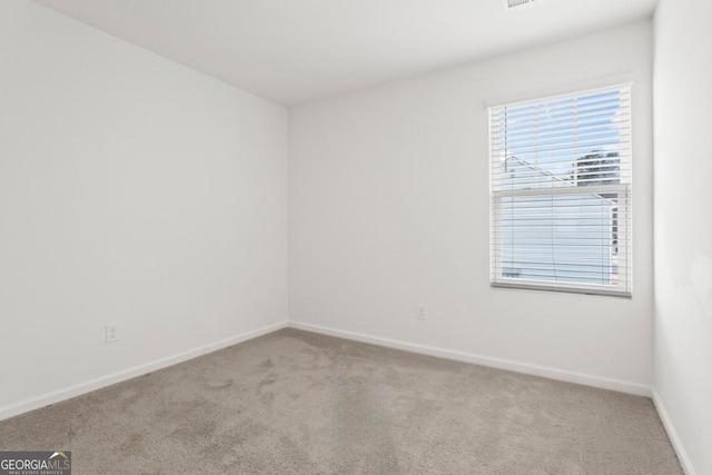 unfurnished room featuring light carpet