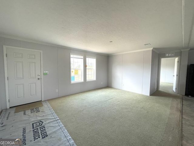 carpeted spare room featuring crown molding and a textured ceiling