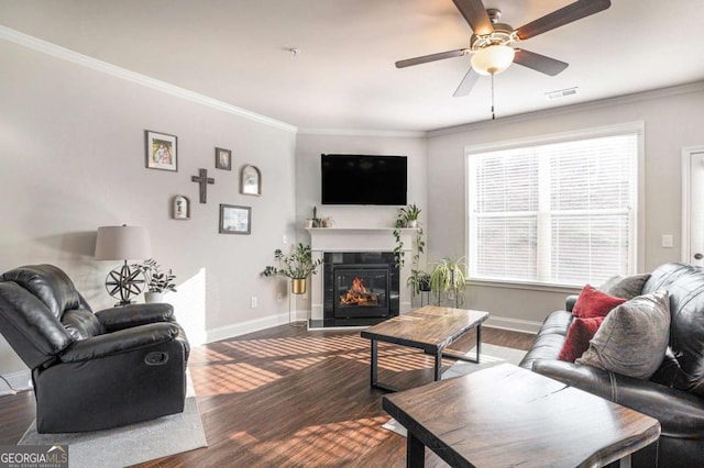 living room with ornamental molding, dark hardwood / wood-style floors, and ceiling fan