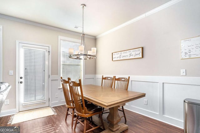 dining room featuring dark hardwood / wood-style flooring, ornamental molding, and a chandelier