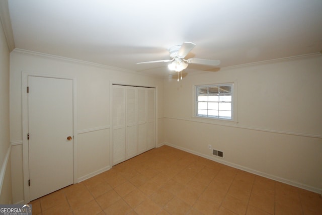 unfurnished bedroom featuring crown molding, a closet, and ceiling fan