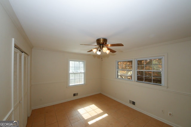 unfurnished bedroom with crown molding, ceiling fan, and a closet