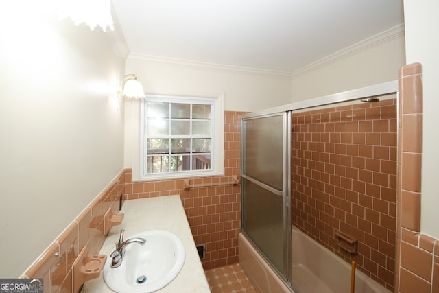 bathroom with ornamental molding, bath / shower combo with glass door, vanity, and tile walls