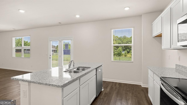 kitchen featuring light stone counters, an island with sink, sink, and white cabinets