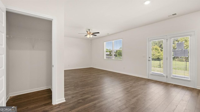 unfurnished bedroom with dark wood-type flooring, access to outside, a closet, and ceiling fan