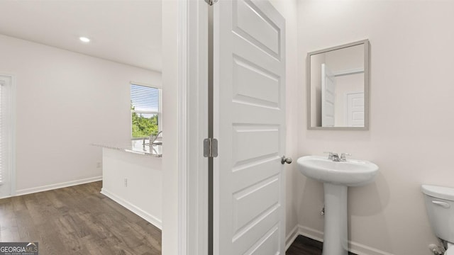 bathroom featuring wood-type flooring, toilet, and sink