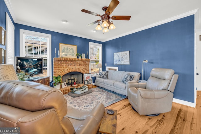 living room featuring hardwood / wood-style flooring, ornamental molding, plenty of natural light, and a fireplace