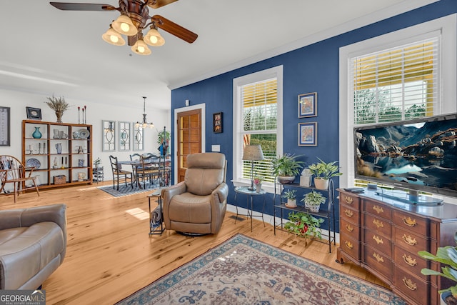 sitting room with hardwood / wood-style floors, crown molding, and ceiling fan