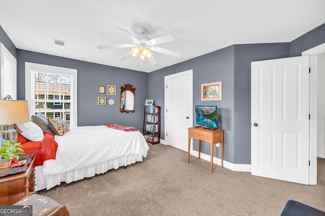 carpeted bedroom featuring ceiling fan and a closet