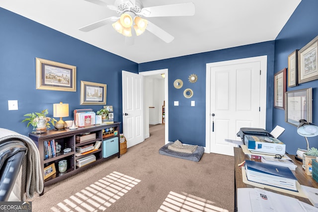 carpeted office space featuring ceiling fan