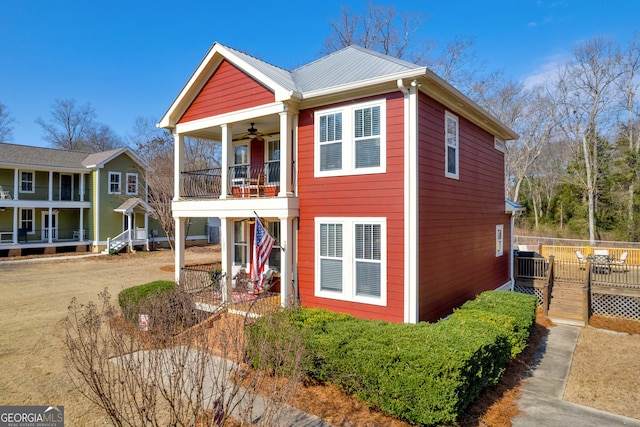 view of front of house featuring a balcony and ceiling fan