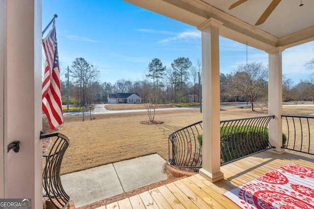 wooden terrace featuring ceiling fan and a porch