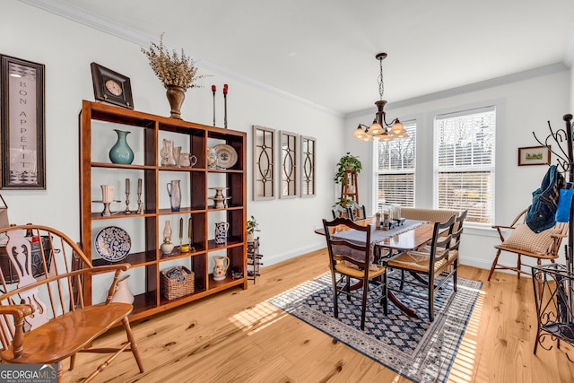 dining area featuring hardwood / wood-style flooring, ornamental molding, and a notable chandelier