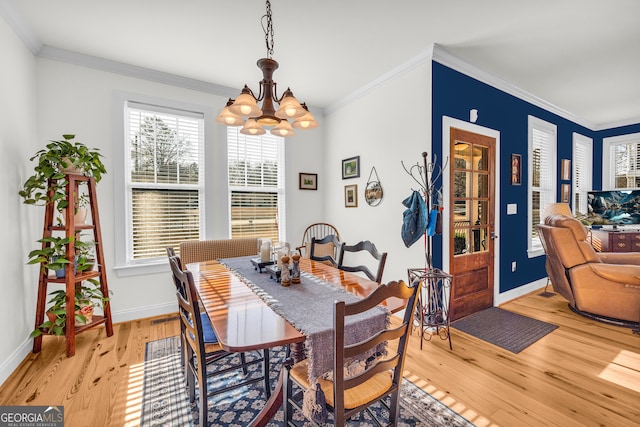 dining room featuring ornamental molding, a notable chandelier, and light hardwood / wood-style flooring