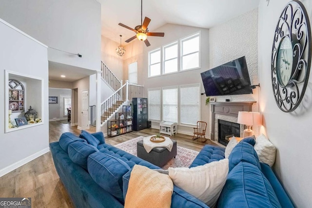 living room featuring ceiling fan, high vaulted ceiling, and light hardwood / wood-style floors