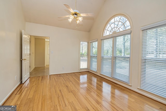 unfurnished room with high vaulted ceiling, light hardwood / wood-style floors, and ceiling fan