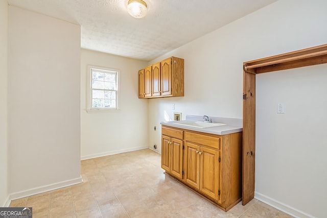 clothes washing area featuring sink, cabinets, hookup for a washing machine, electric dryer hookup, and a textured ceiling