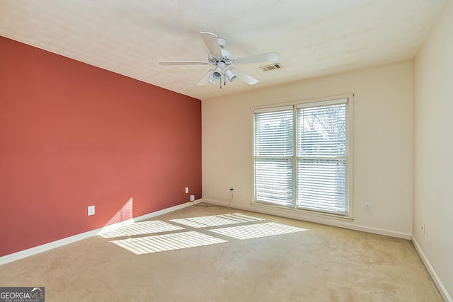 spare room with light carpet and ceiling fan