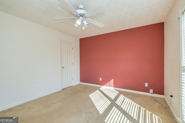 carpeted spare room with a textured ceiling and ceiling fan