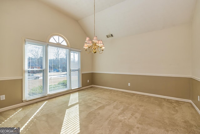 carpeted spare room with vaulted ceiling and a chandelier