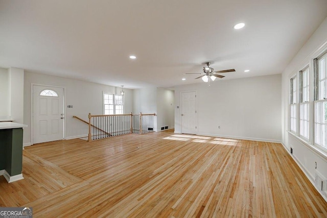 unfurnished living room featuring ceiling fan and light wood-type flooring