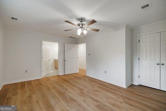 unfurnished bedroom featuring ornamental molding, a closet, ensuite bathroom, and light hardwood / wood-style flooring