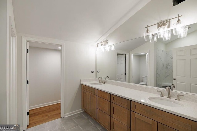 bathroom featuring vanity, toilet, tile patterned flooring, and vaulted ceiling