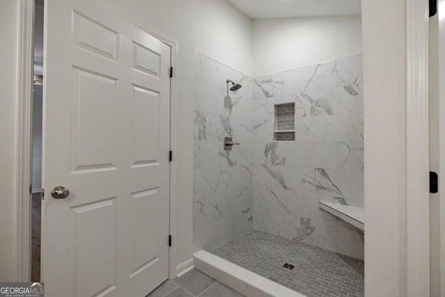 bathroom featuring a tile shower and tile patterned floors