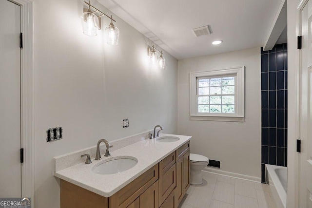 bathroom featuring vanity, a bath, and toilet