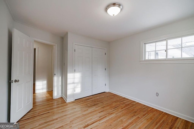 unfurnished bedroom featuring light wood-type flooring and a closet