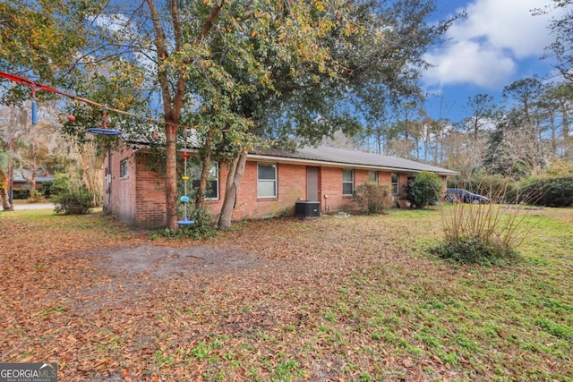 ranch-style house featuring cooling unit and a front lawn