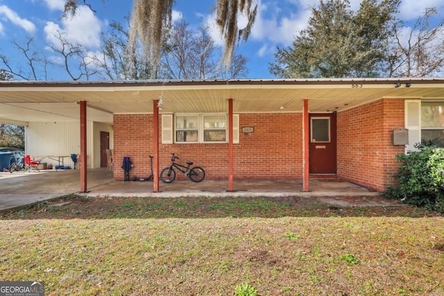 back of property with a carport and a lawn